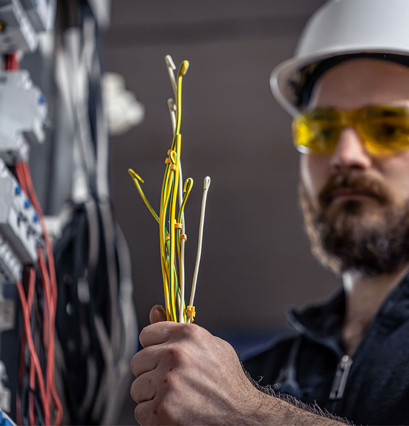 Un électricien tenant des cables de dépannage électrique